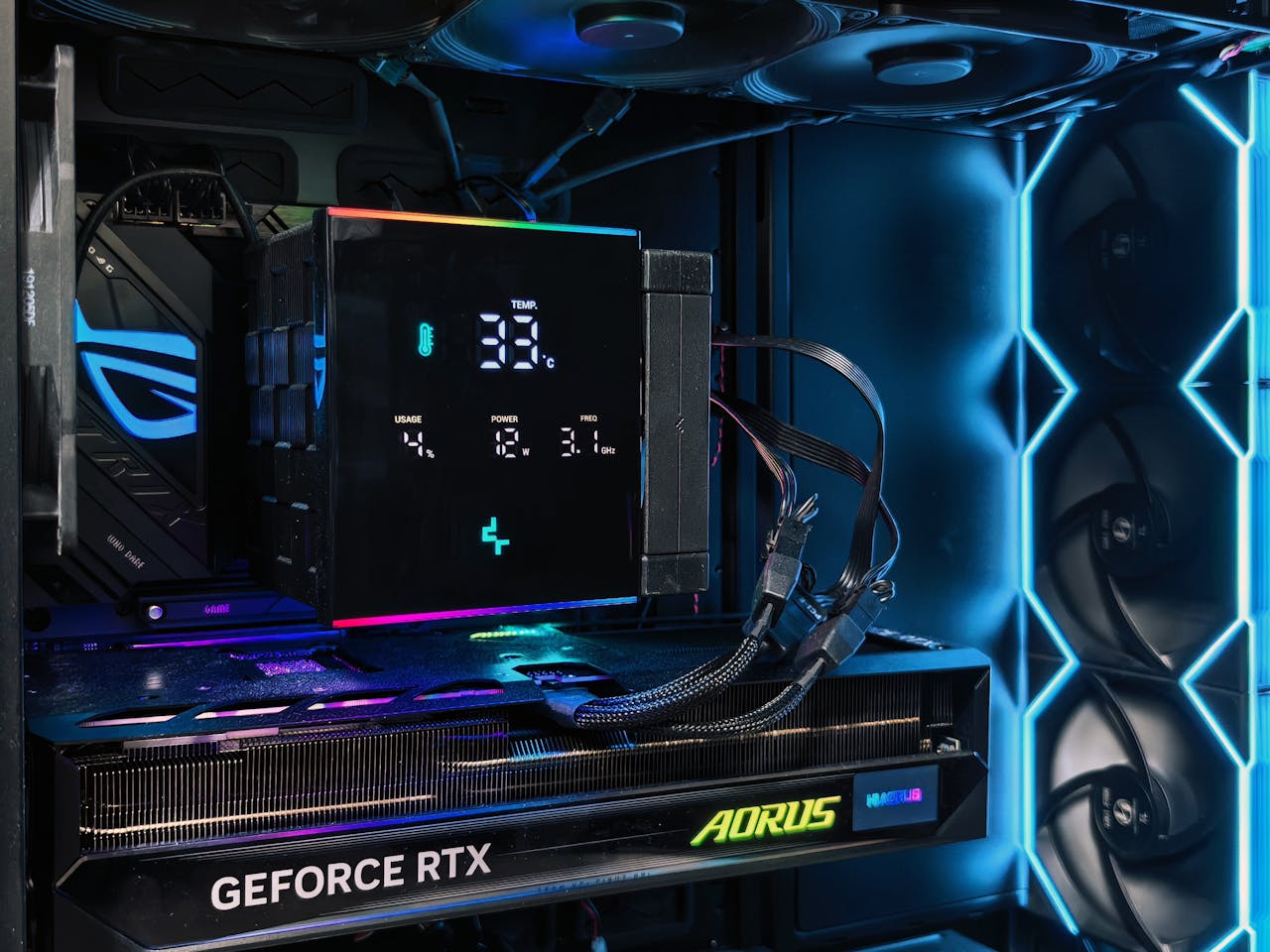 Detailed view of a gaming PC interior featuring an AORUS graphics card and RGB lighting setup.